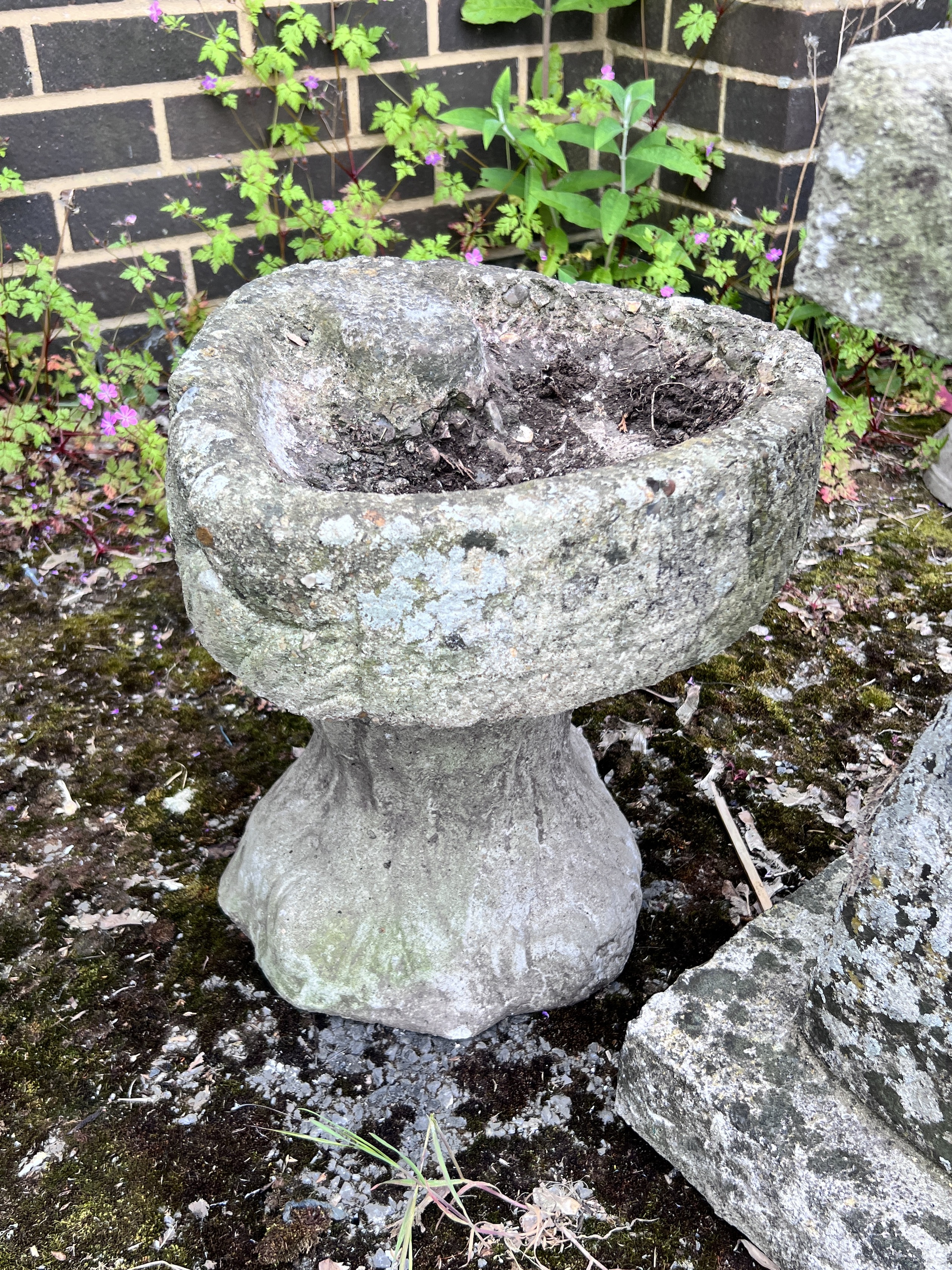 A sphere sundial on reconstituted stone plinth, height 85cm, and a smaller shell shaped bird bath